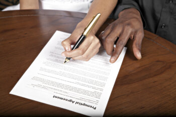 A couple signs a prenuptial agreement