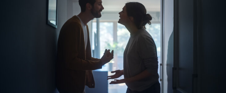 Young Couple Arguing and Fighting. Domestic Violence and Emotional abuse Scene, Stressed Woman and aggressive Man Screaming at Each other in the Dark Hallway of Apartment. Dramatic Scene