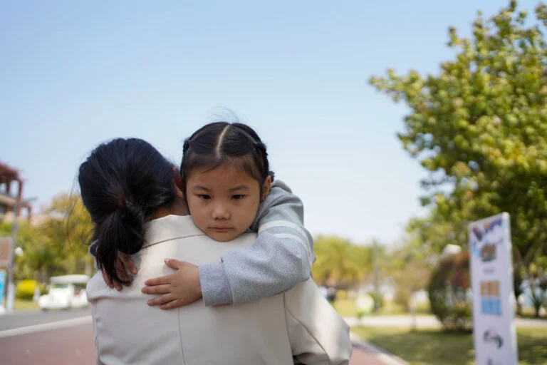 Young child embracing woman.
